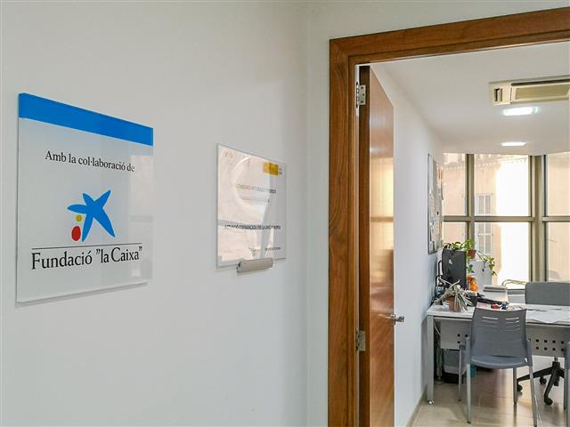 placa amb el logotip de la Fundació La Caixa a la porta del servei d'inclusió sociolaboral